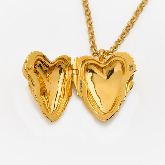 Gold heart-shaped locket on a chain against a white background