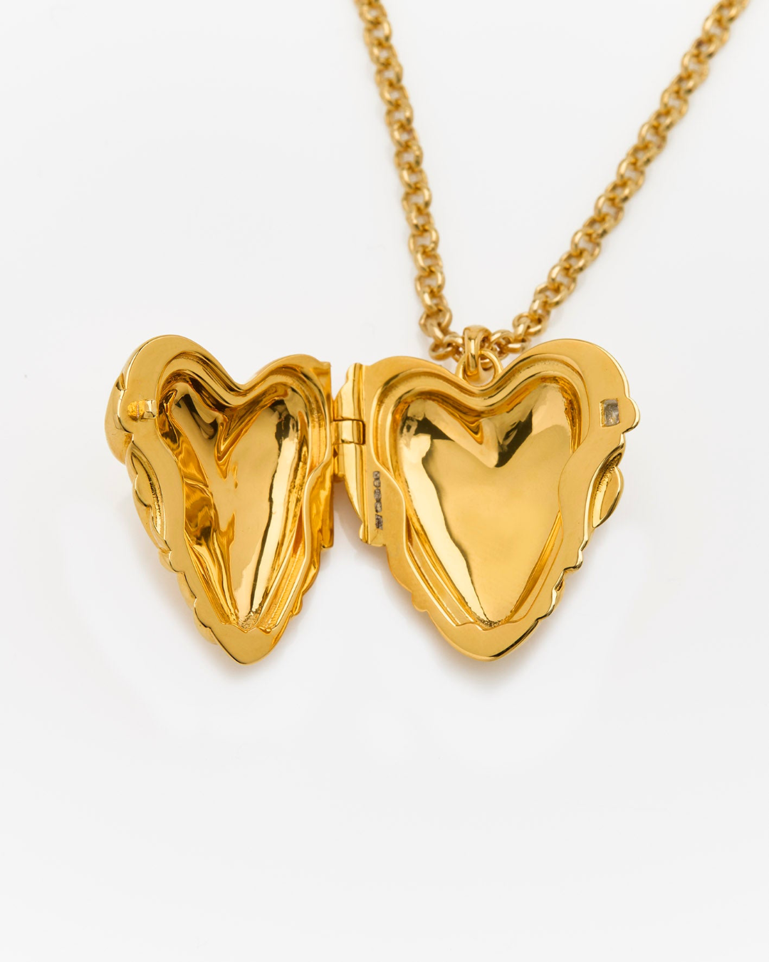 Gold heart-shaped locket on a chain against a white background