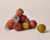 Silver jewelry pieces on lychee fruits against a neutral background
