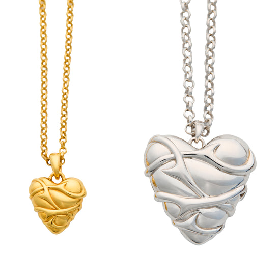 Gold and silver heart-shaped pendants on white background
