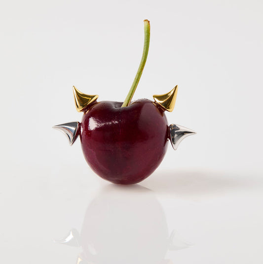 Decorative cherry with gold horns and silver wings on a white background