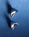 Pair of silver spike earrings on a blue background