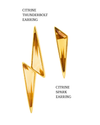 Gold earrings shaped like lightning bolts on a white background