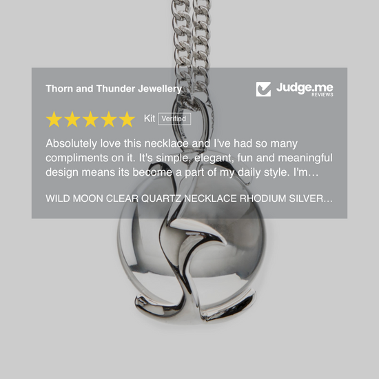 Silver necklace with clear quartz stones on a gray background, featuring a 5-star rating and review.